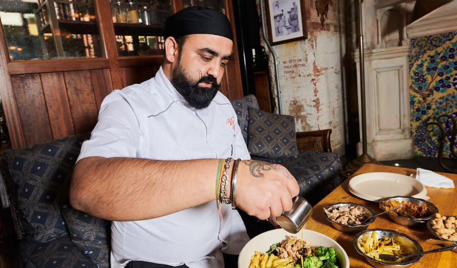man serving up chicken salad