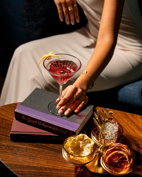 hand holding a cocktail on a table