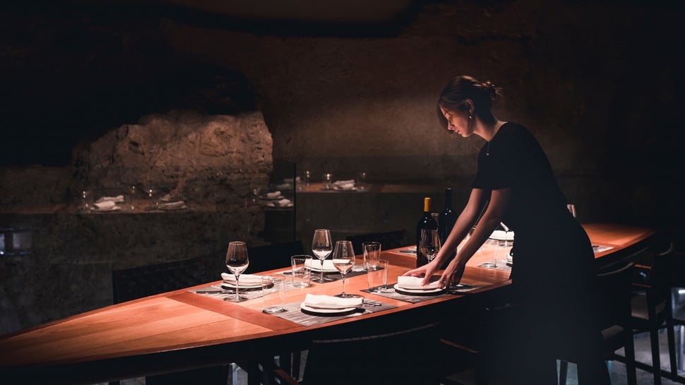 Staff setting up an elegant table at a fine dining restaurant, focusing on exceptional guest experience