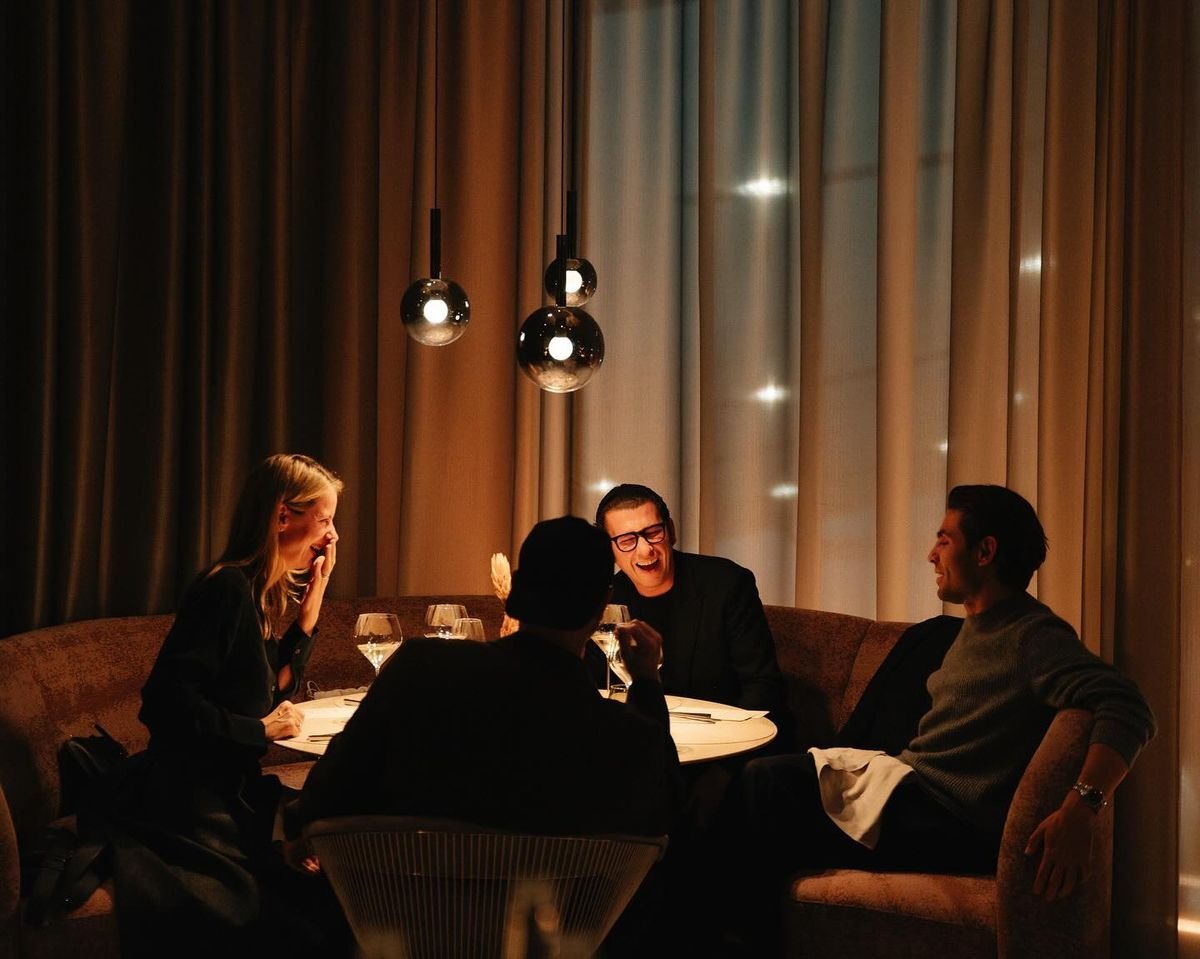 guests laughing around a restaurant table