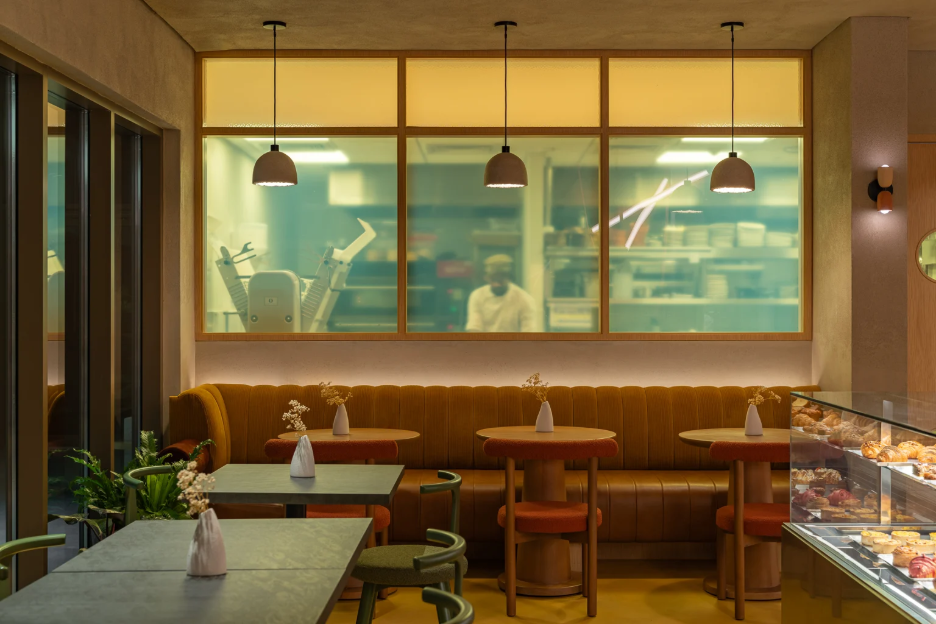 Cafe dining area and kitchen view with pastries
