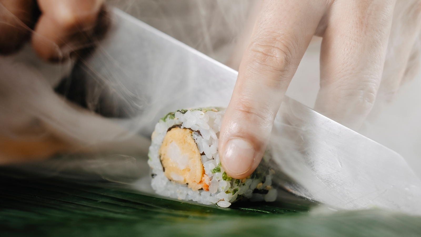 Chef slicing sushi roll with precision, symbolising excellence in restaurant operations